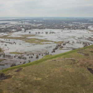 Aerial shot of floodplains inundating the grasses and low-laying forests.